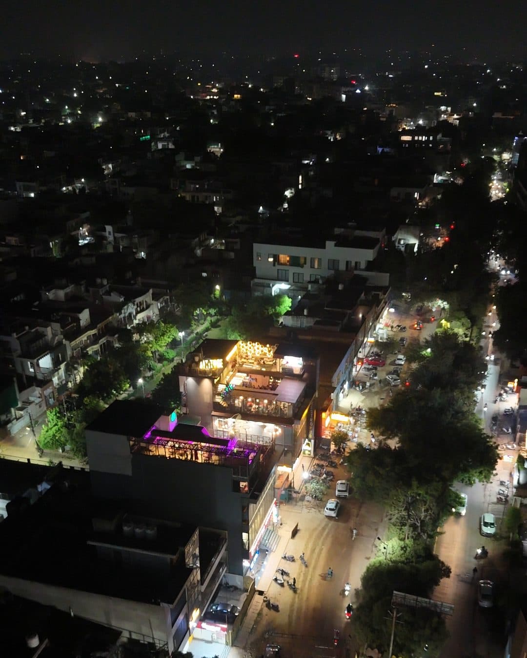 Agra at night from the air above MG Road 2: lit rooftops and streets in the foreground and the city’s lights spreading to a dark horizon